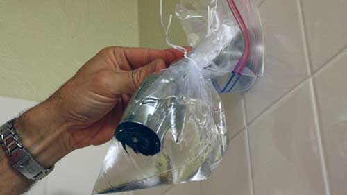 18 Cover your shower with a bag of vinegar to remove stains