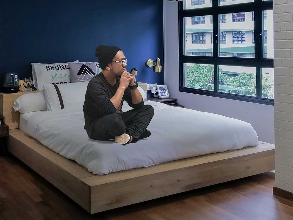 Man wondering how long it takes to renovate in Singapore on his bed